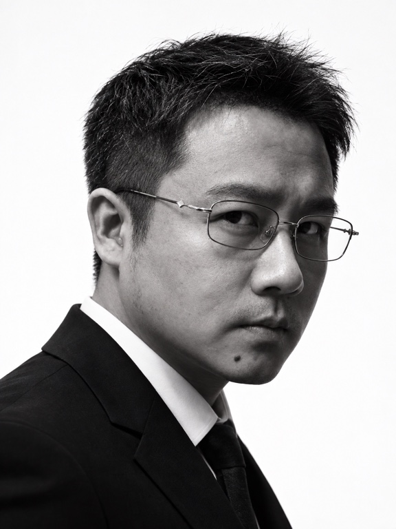龙哥穿黑白西装回望镜头的形象照